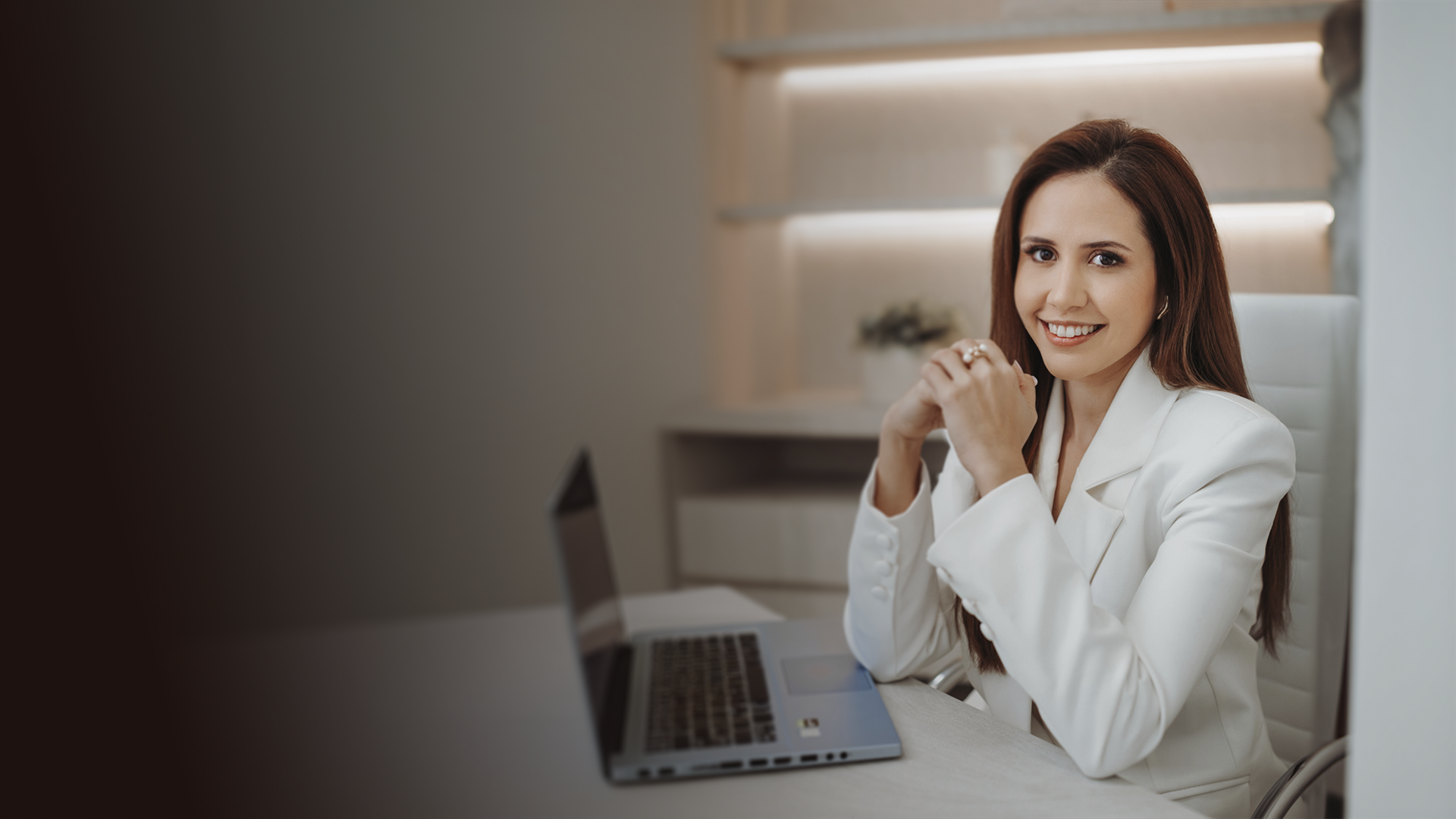 Dra. Daniella Andretta em seu consultório, com blazer branco